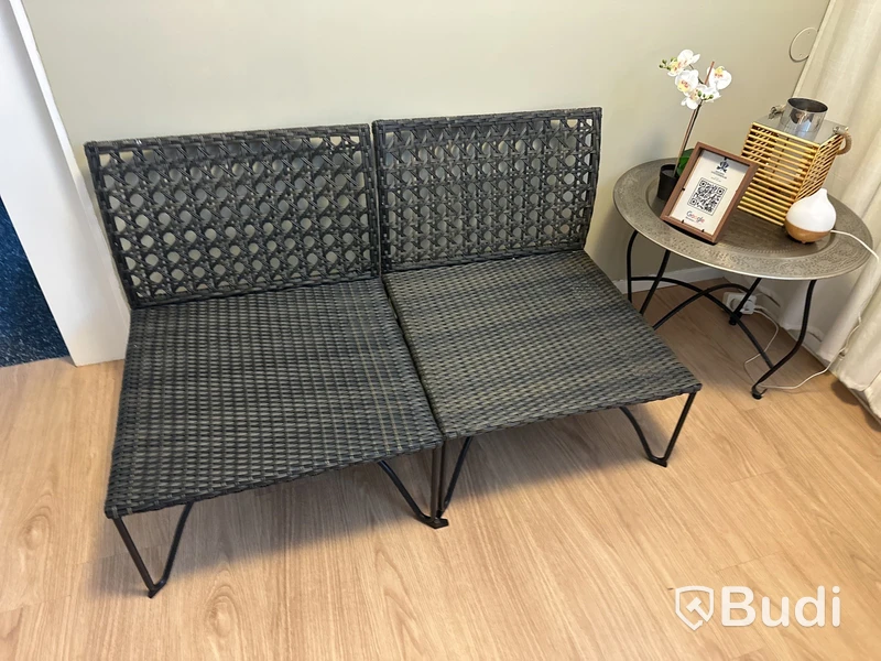 Soffa i rotting bredd 2x 65 cm, sitthöjd 35 cm med dynor. Runt bord i metall,  lykta mm.