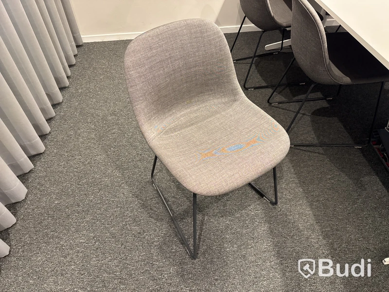 Konferensrum med bord, stolar, skärm och konferensutrustning