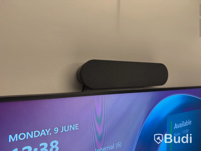 Konferensrum med bord, stolar, skärm och konferensutrustning