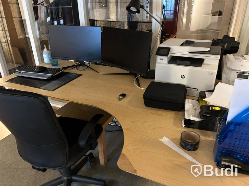 Kontorsrum med skrivbord, stolar, bord, förvaring, datorskärmar, skrivare