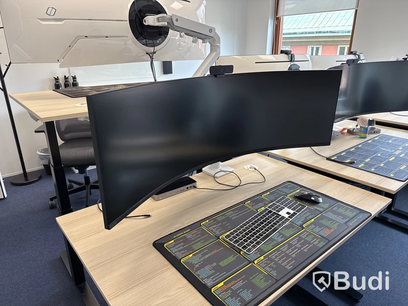 Samsung 49 tum curved datorskärm med bordfäste USB-docka samt logitech kamera. Skärmen är C49G95TSSR