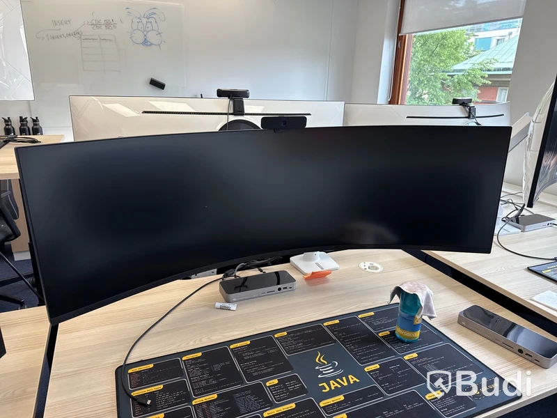 Samsung 49 tum curved datorskärm med bordfäste USB-docka samt logitech kamera. Skärmen är C49G95TSSR