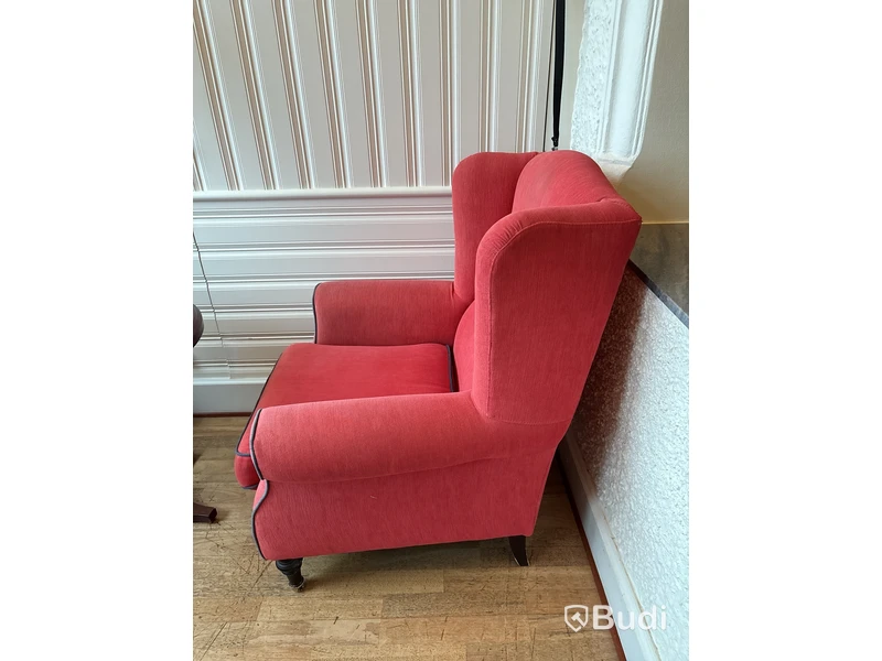 Fåtölj med fotpall, soffbord och vägglampa