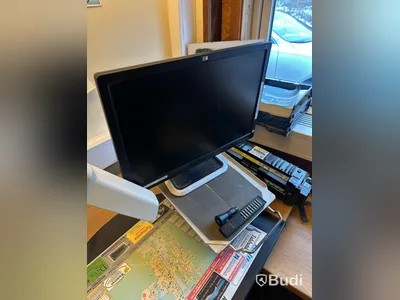 Skrivbord med HP-datorskärm och arbetslampa