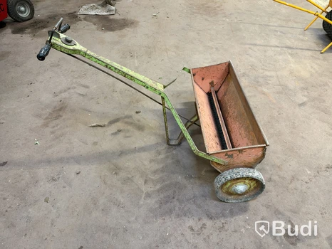 Handdragen spridare med behållare