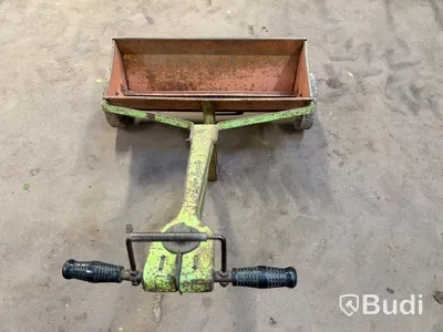 Handdragen spridare med behållare