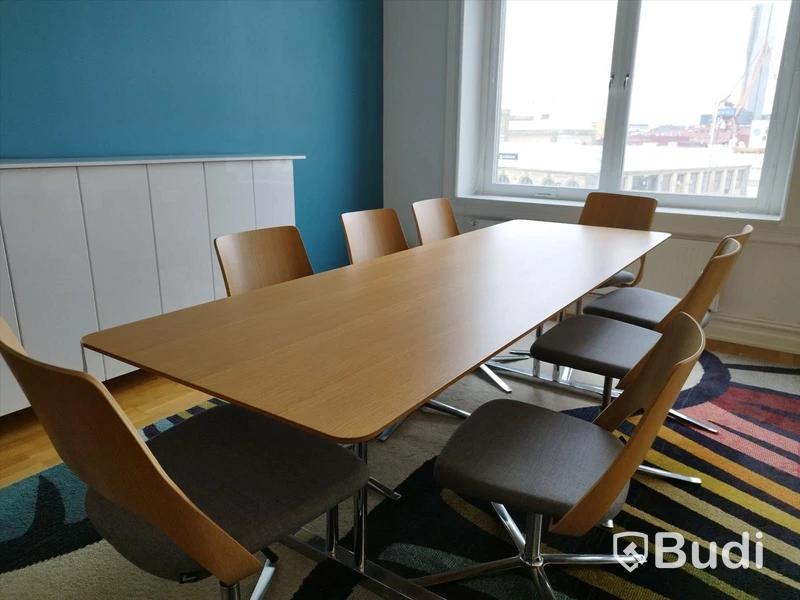 Konferensrum, bord med 8 st stolar, arbetsplats med skärmar m.m.