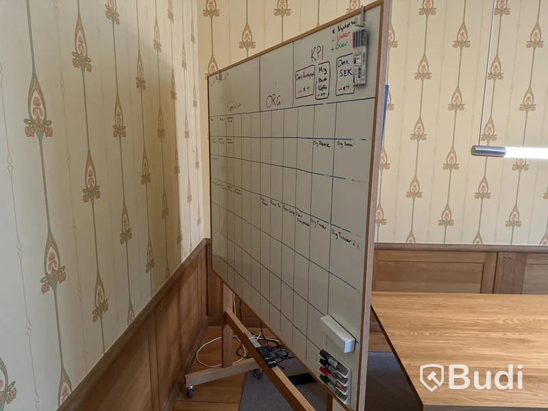 TV med konferensutrustning på stativ med whiteboard-tavla