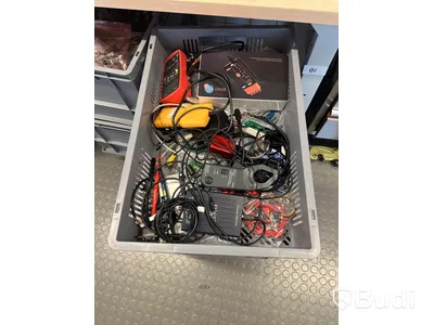 Diverse elverktyg och elkomponenter i backar på hjul