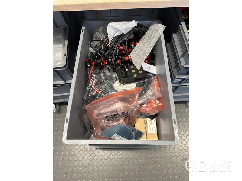 Diverse elverktyg och elkomponenter i backar på hjul