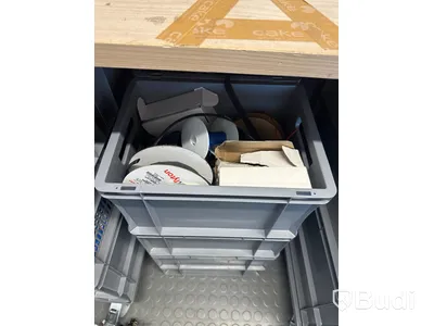 Diverse elverktyg och elkomponenter i backar på hjul