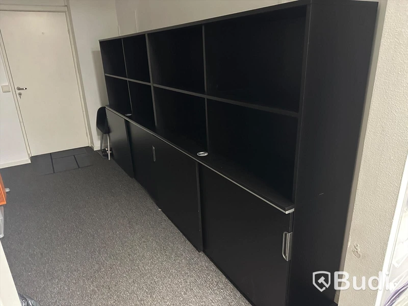 Kontorsarbetsplats med bord, 1 besöksstol, 2 hyllsektioner med skjutdörrar.
