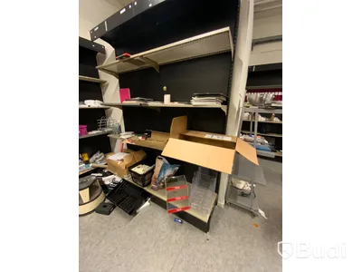 18st sektioner butiksinredning, hyllor utmed vägg, både vinklade hyllplan för böcker samt raka för diverse varor.