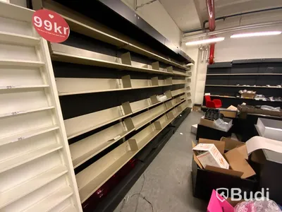 18st sektioner butiksinredning, hyllor utmed vägg, både vinklade hyllplan för böcker samt raka för diverse varor.