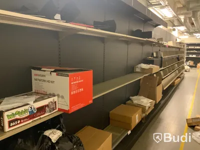 12st sektioner butiksinredning, hyllor utmed vägg, både vinklade hyllplan för böcker samt raka för diverse varor.