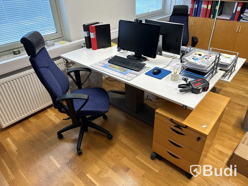 Höj- och sänkbart skrivbord, skärm, kontorsstol och hurts.