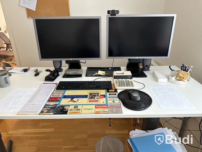 Höj- och sänkbart skrivbord, två datorskärmar, tangentbord, datormus, hurts och kontorsstol