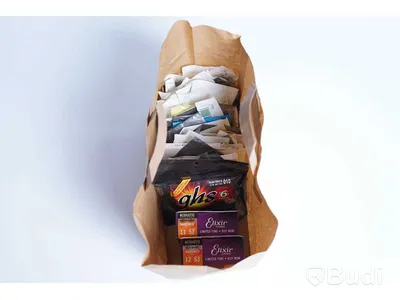 Diverse gitarrtillbehör. Strängar, capo, stämskruvar, plektrumskydd, rengöringstrasa, intonationsverktyg och adapter.