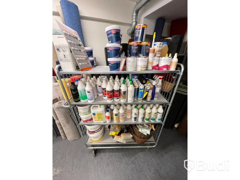 Rullvagn med div produkter för mattläggning och rengöring.