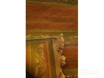 Handknuten matta i en härlig färgkombination av grön, orange, beige och detaljer i vitt, ca 59 x 110 cm