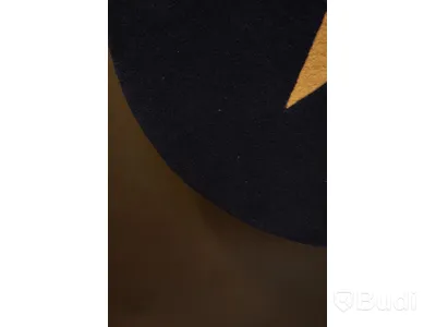 Handtuftad matta i en mörkblå färg med en vit stjärna i mitten.  Denna runda matta har en diameter på ca 88 cm.