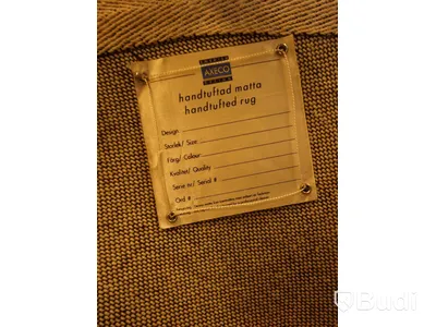 Handtuftad matta i en mörkblå färg med en vit stjärna i mitten.  Denna runda matta har en diameter på ca 88 cm.