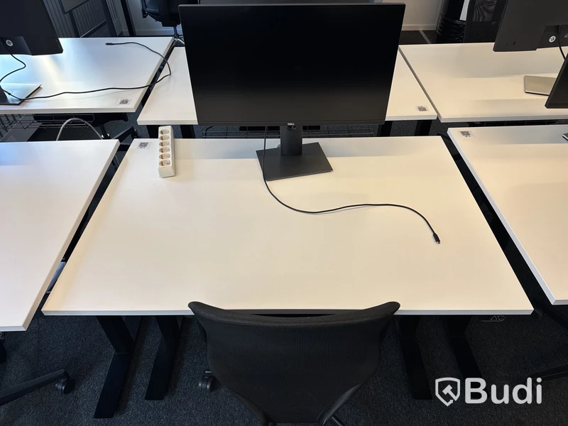 Höj- och sänkbart skrivbord med kontorsstol och datorskärm