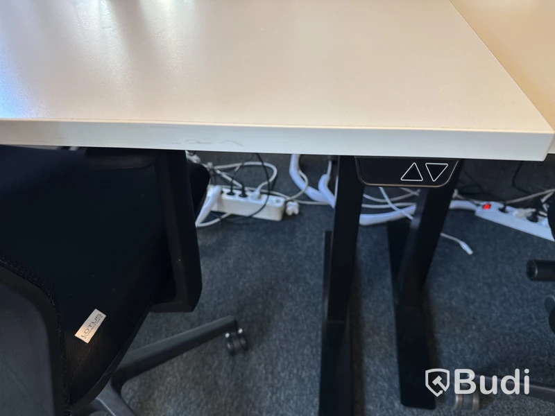 Höj- och sänkbart skrivbord med kontorsstol och datorskärm