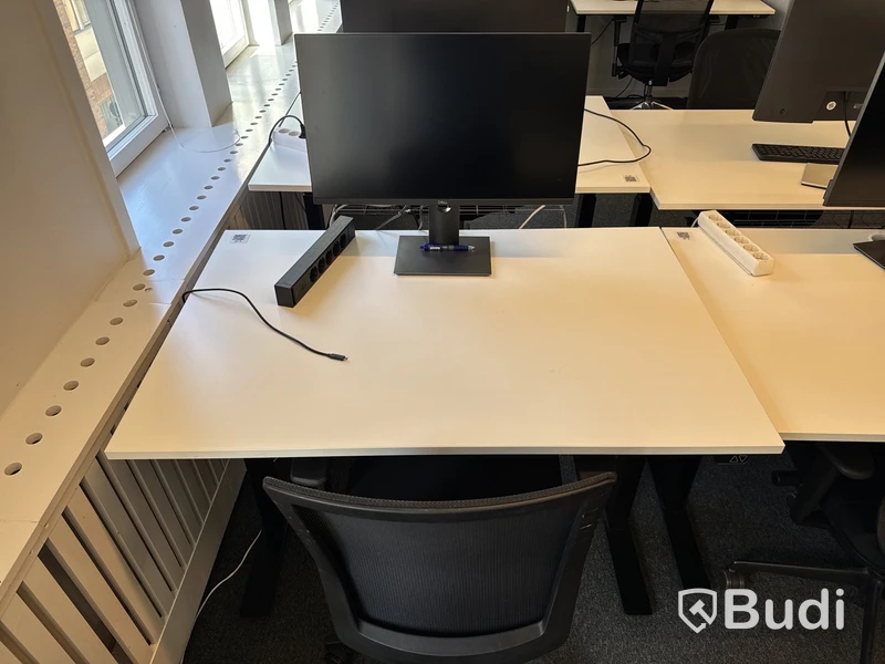 Höj- och sänkbart skrivbord med kontorsstol och datorskärm