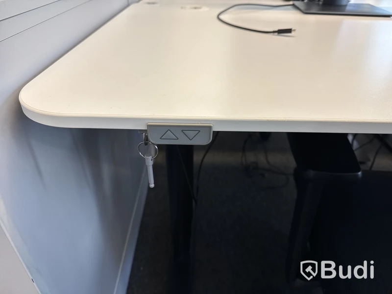 Höj- och sänkbart skrivbord med kontorsstol och datorskärm