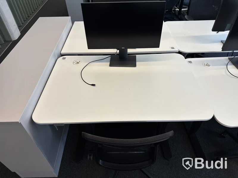 Höj- och sänkbart skrivbord med kontorsstol och datorskärm