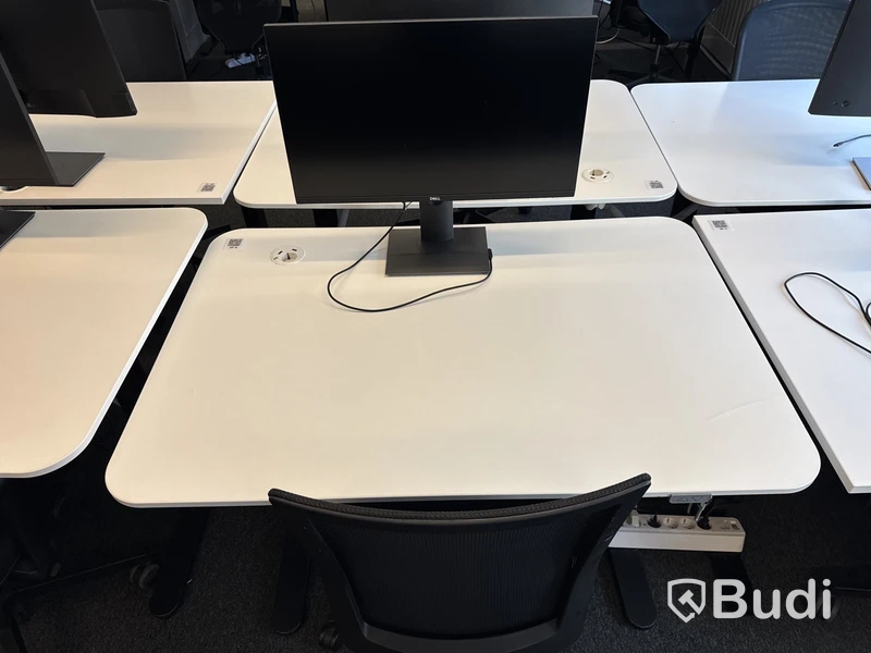Höj- och sänkbart skrivbord med kontorsstol och datorskärm