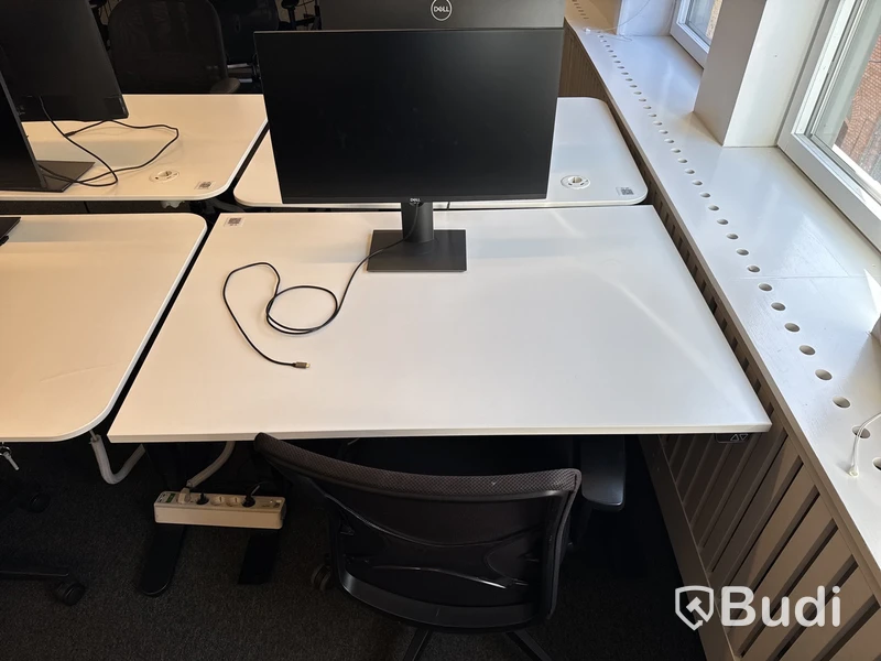 Höj- och sänkbart skrivbord med kontorsstol och datorskärm