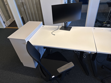 Höj- och sänkbart skrivbord, kontorsstol och datorskärm