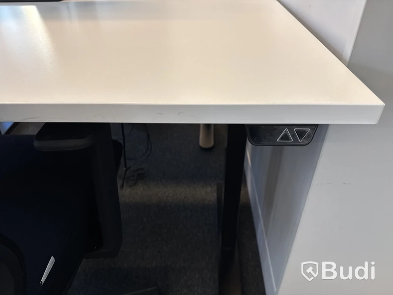 Höj- och sänkbart skrivbord med kontorsstol och datorskärm