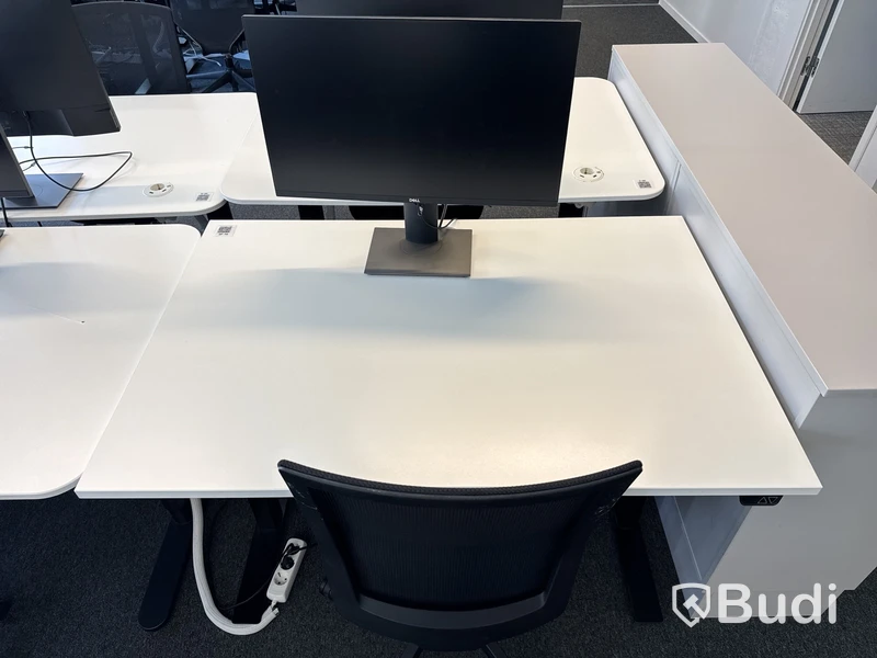 Höj- och sänkbart skrivbord med kontorsstol och datorskärm