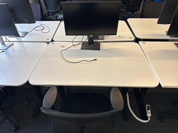 Höj- och sänkbart skrivbord med kontorsstol och datorskärm