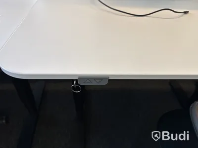 Höj- och sänkbart skrivbord med kontorsstol och datorskärm