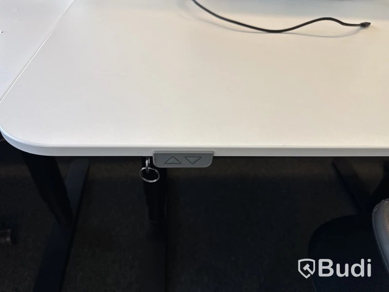 Höj- och sänkbart skrivbord med kontorsstol och datorskärm