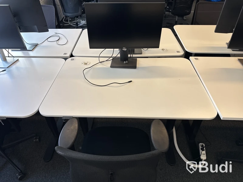Höj- och sänkbart skrivbord med kontorsstol och datorskärm