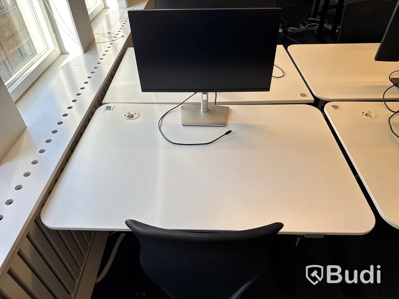 Höj- och sänkbart skrivbord med kontorsstol och datorskärm
