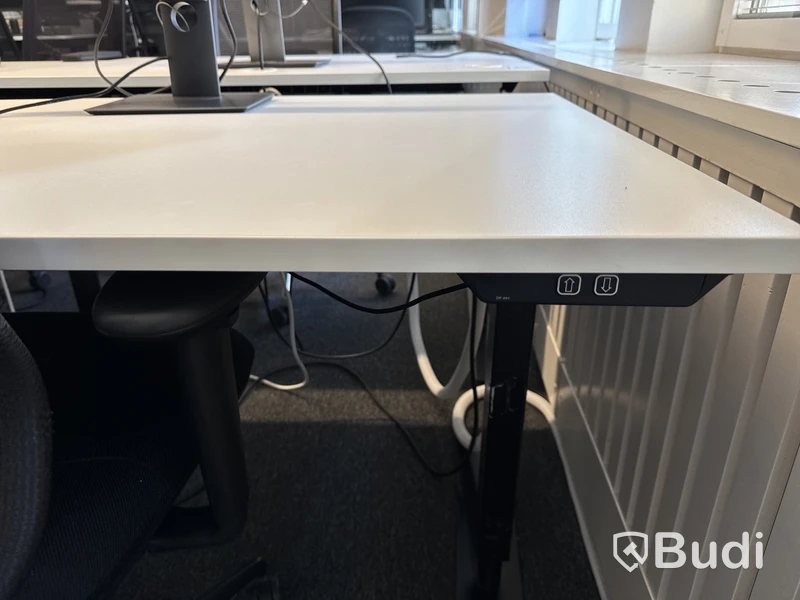 Höj- och sänkbart skrivbord med kontorsstol och datorskärm