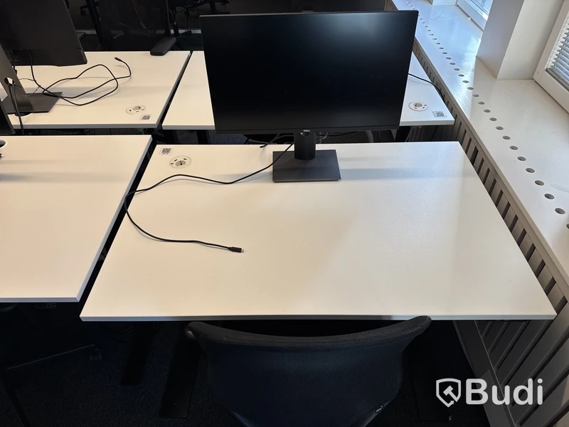 Höj- och sänkbart skrivbord med kontorsstol och datorskärm