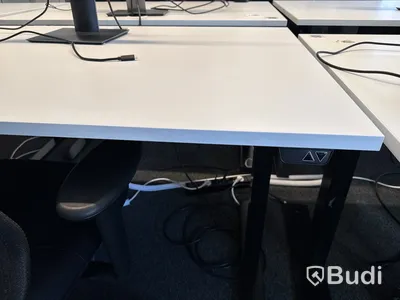 Höj- och sänkbart skrivbord med kontorsstol och datorskärm