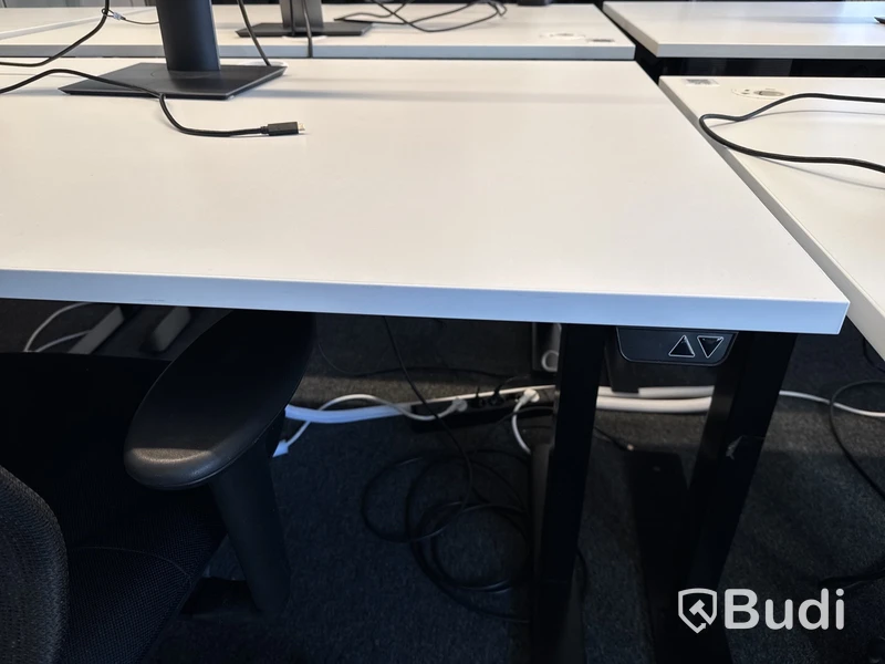 Höj- och sänkbart skrivbord med kontorsstol och datorskärm