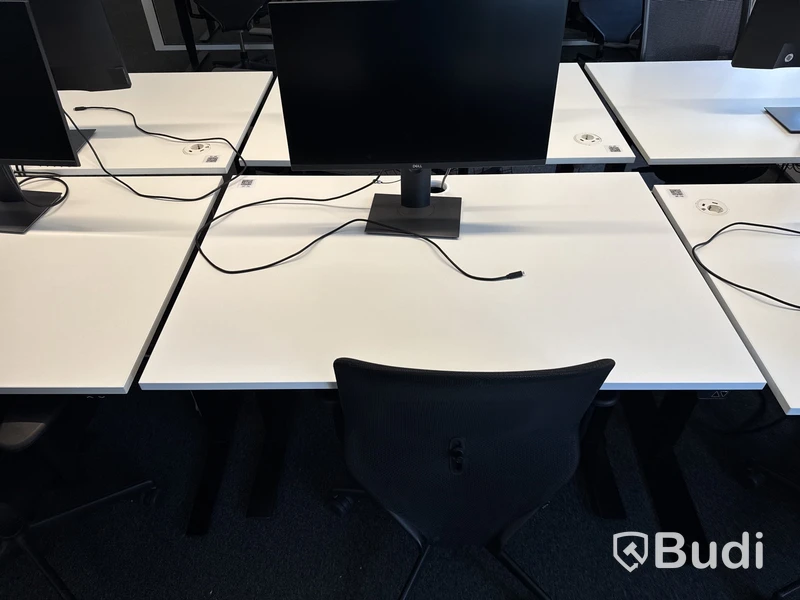 Höj- och sänkbart skrivbord med kontorsstol och datorskärm