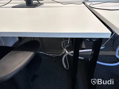 Höj- och sänkbart skrivbord med kontorsstol och datorskärm