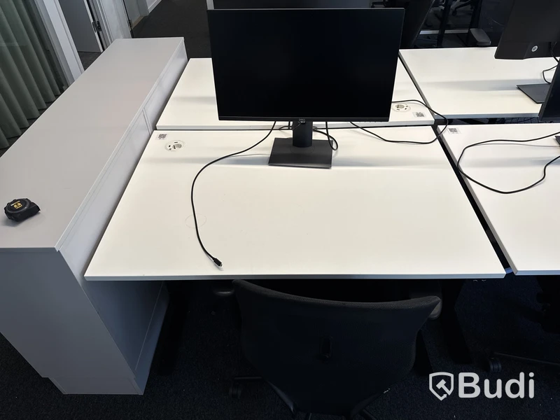 Höj- och sänkbart skrivbord med kontorsstol och datorskärm