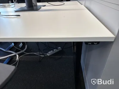 Höj- och sänkbart skrivbord med kontorsstol och datorskärm