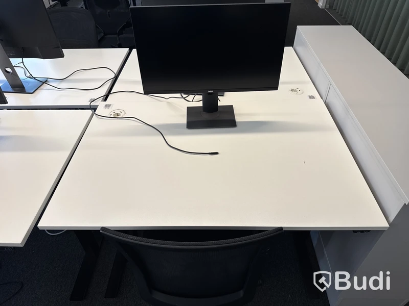 Höj- och sänkbart skrivbord med kontorsstol och datorskärm